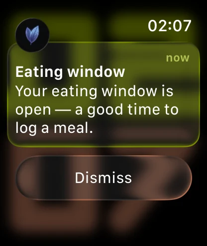 An Apple Watch showing a Vyra notification, headed by the periwinkle Vyra leaf mark: Eating window, and the message that your eating window is open, a good time to log a meal.